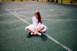 Jeune fille assise sr un court de tennis
