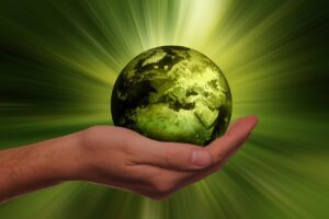 la terre dans une main et des rayons de lumière verte